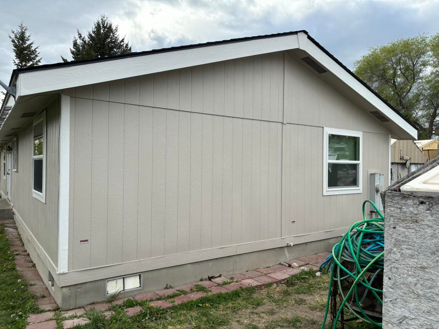 A mobile home with a green hose in front of it