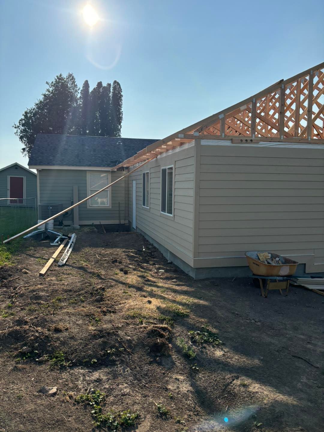A house is being built in the middle of a dirt field.