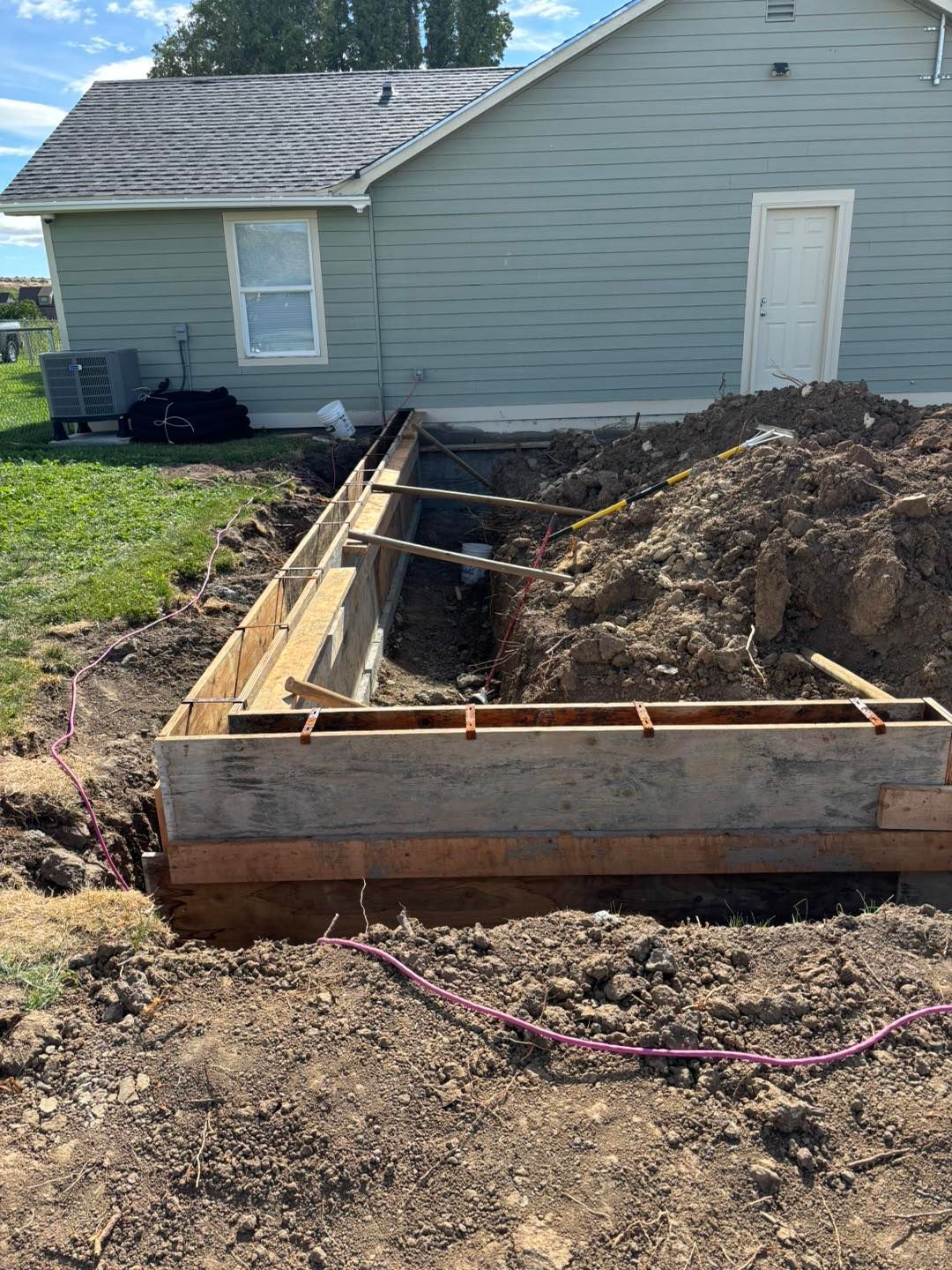 A large pile of dirt is sitting in front of a house.