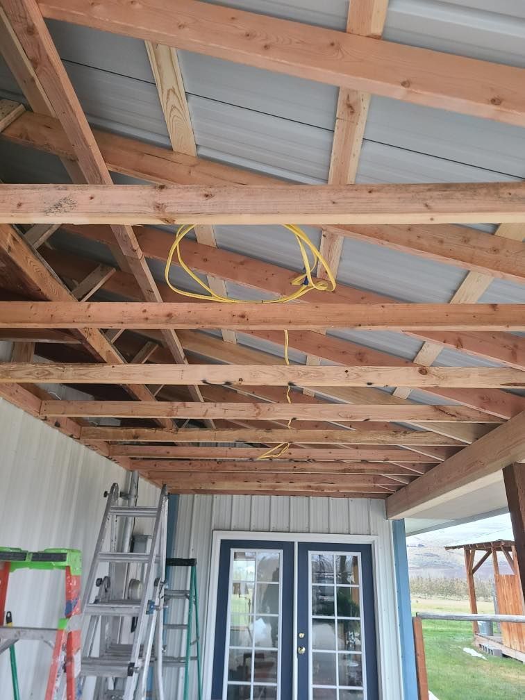 The roof of a building is being built with wooden beams and a ladder.