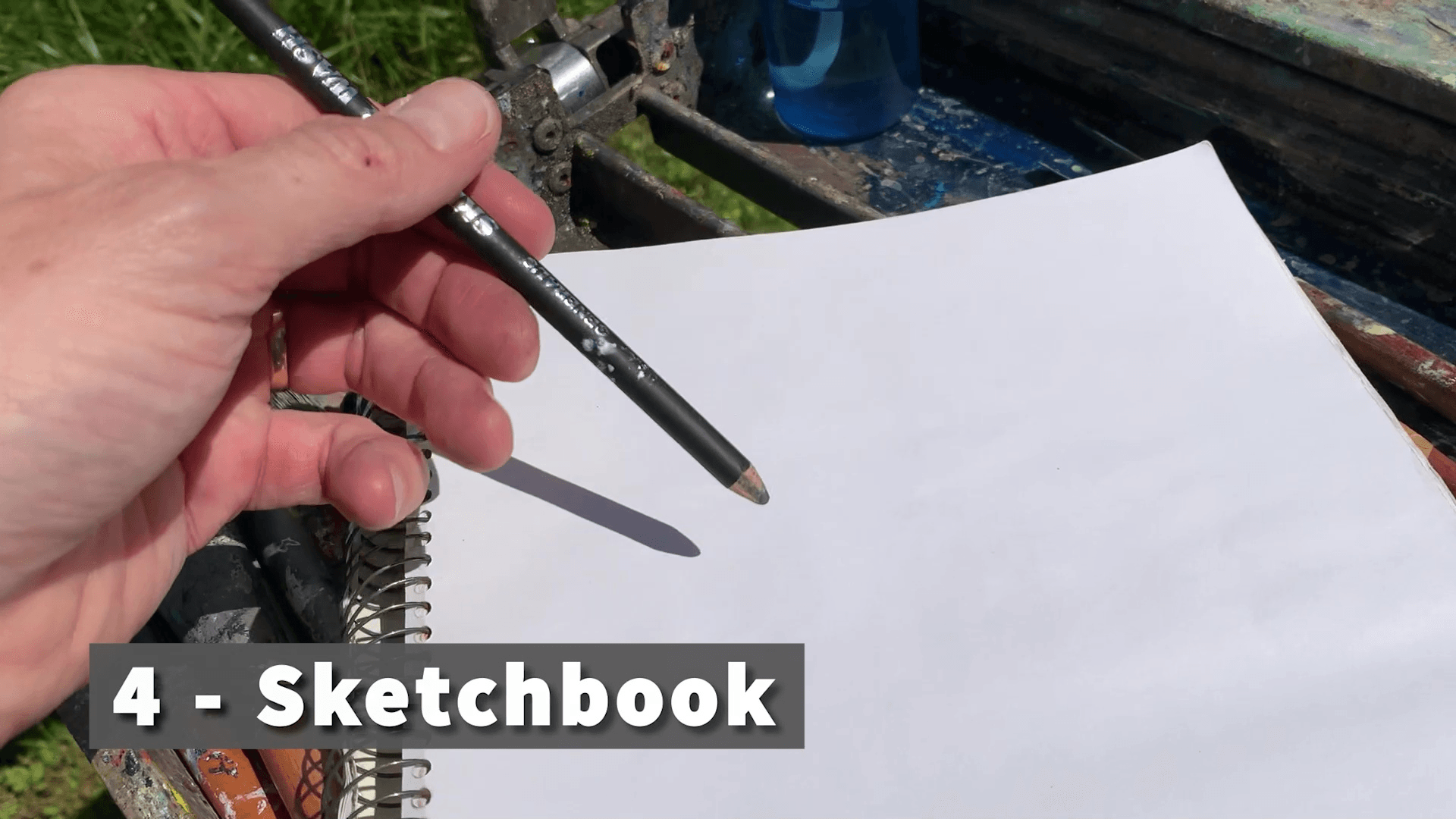 sketchbook with hand holding a pencil for acrylic painting