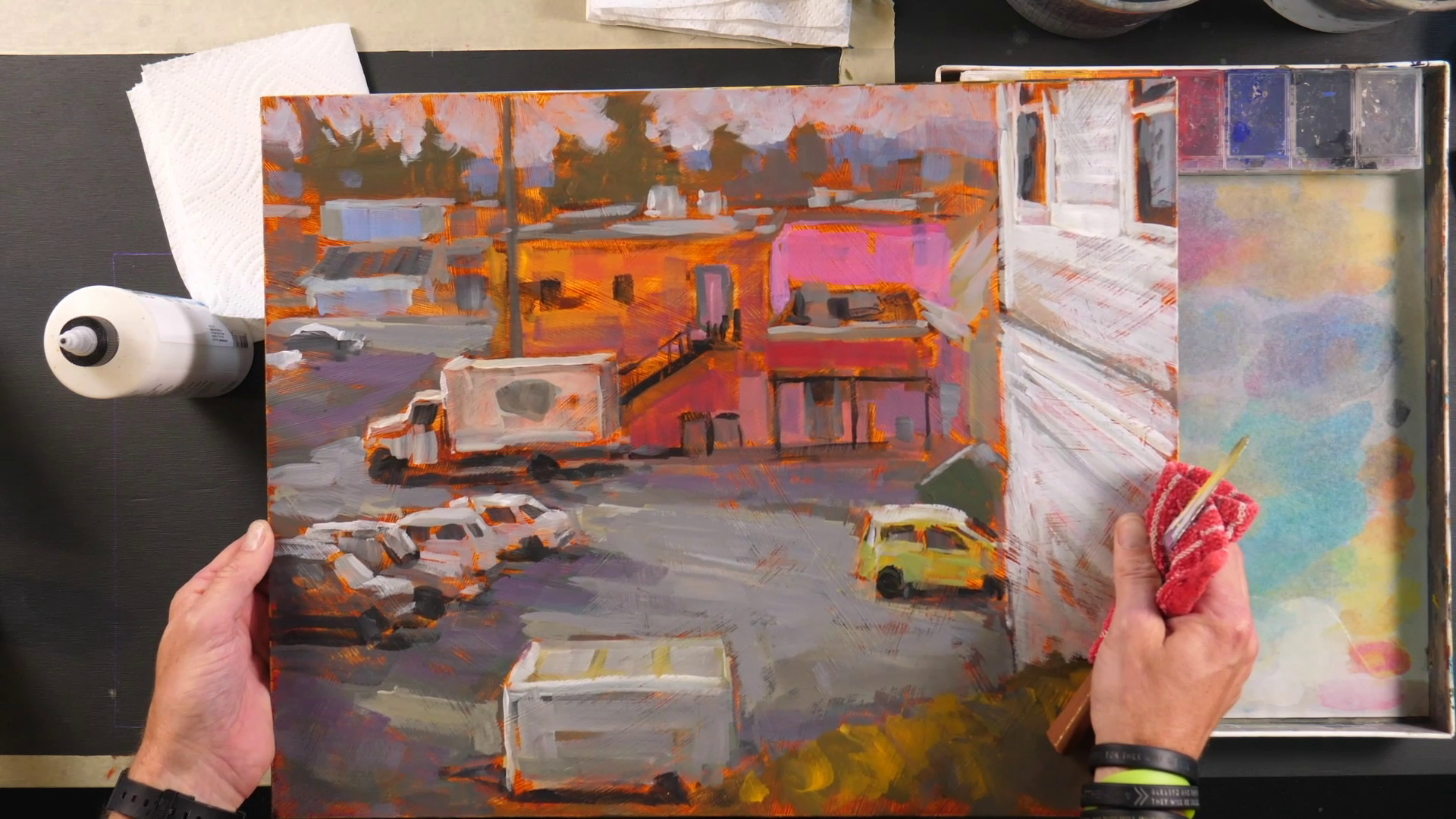 man with acrylic painting of a parking lot in a compound