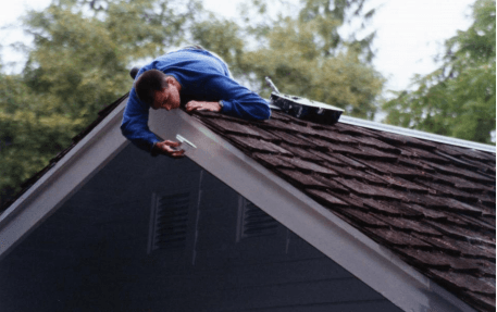 man painting a roof