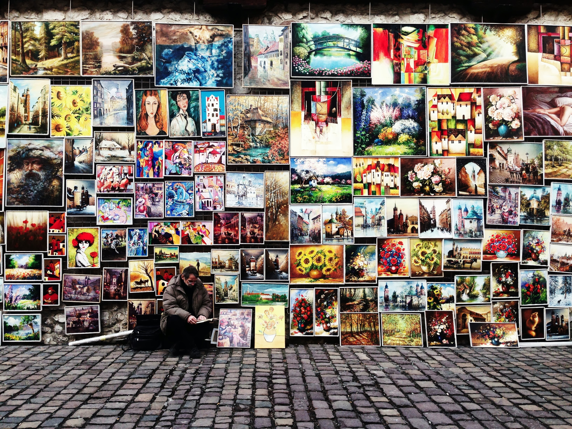 collection of different paintings of an artist by the street