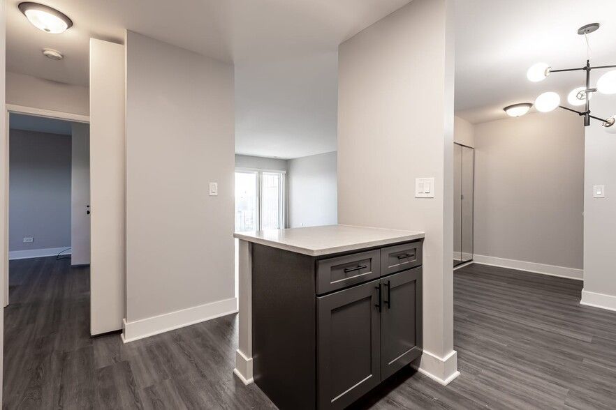 Hallway with dark gray cabinetry, light gray walls, and gray wood-look flooring.