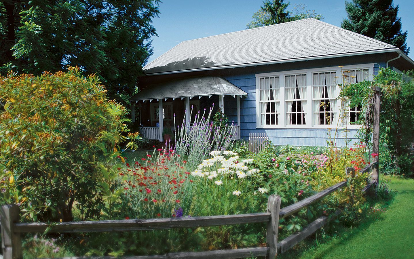 A blue house with a wooden fence in front of it