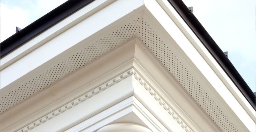 Looking up at the corner of a building with a black gutter