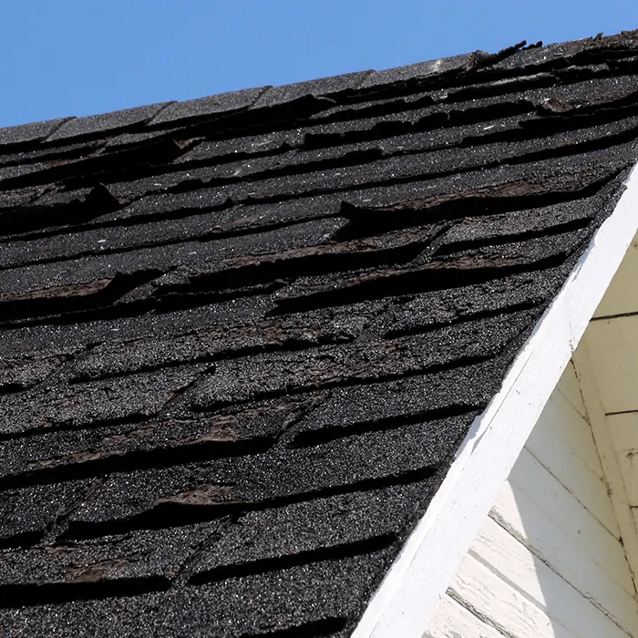 A close up of a roof with black shingles