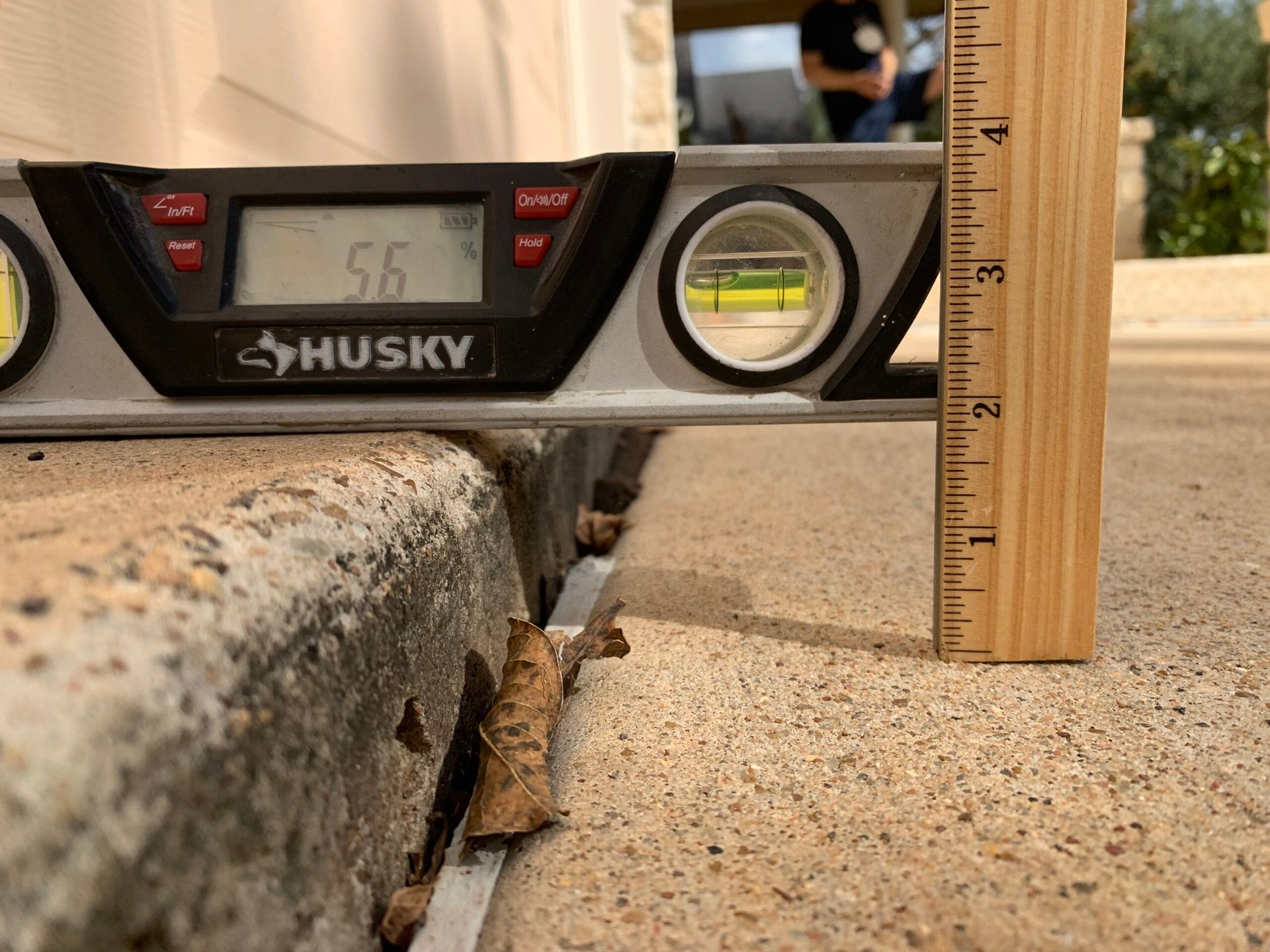 A husky level is being used to measure a concrete surface