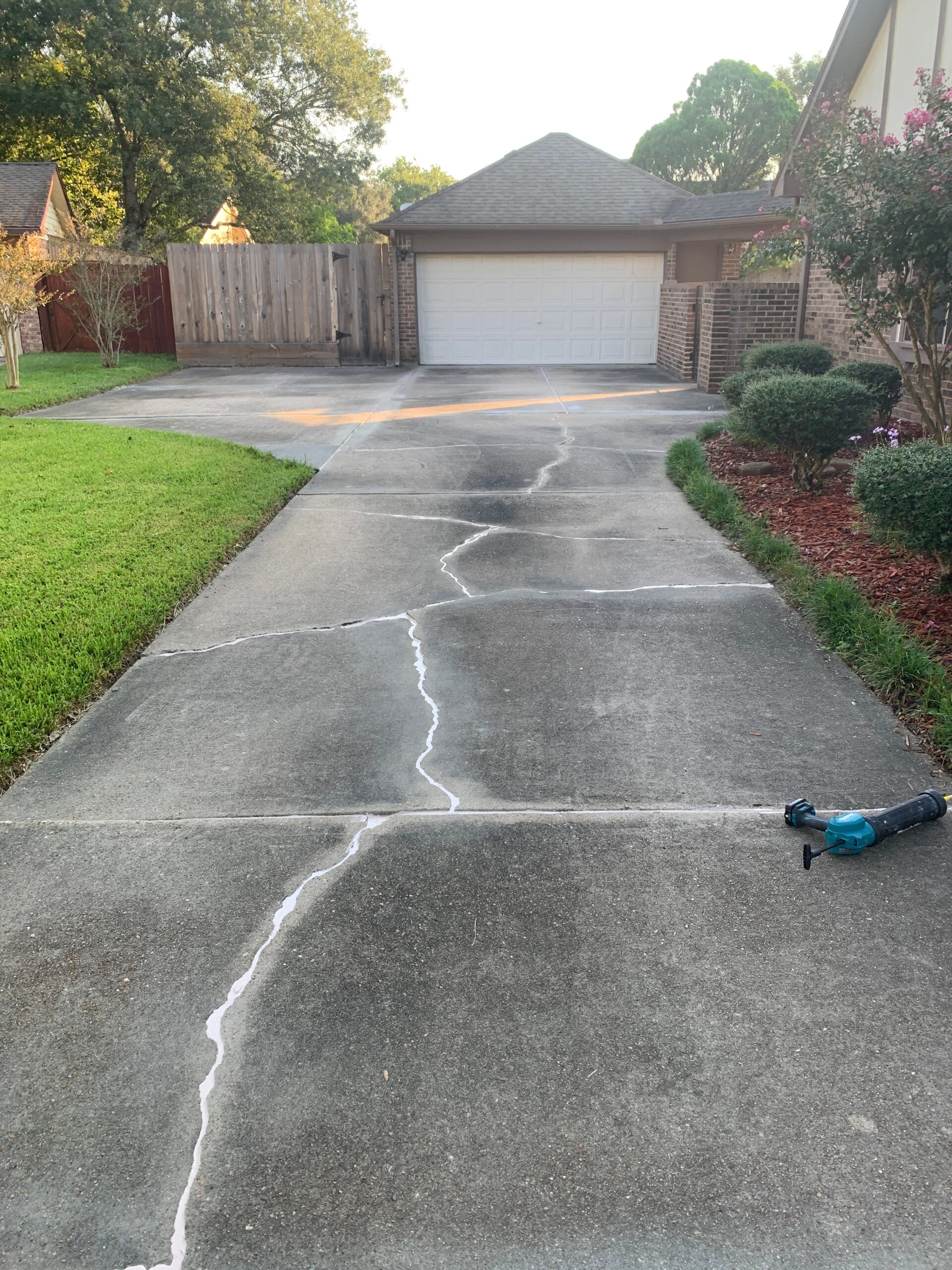 Driveway repair, Expansion joint sealing, Home maintenance, Sealant application, Concrete repair, Residential suburb, Power tool, Property upkeep