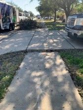 A truck is parked on the side of the road next to a sidewalk.