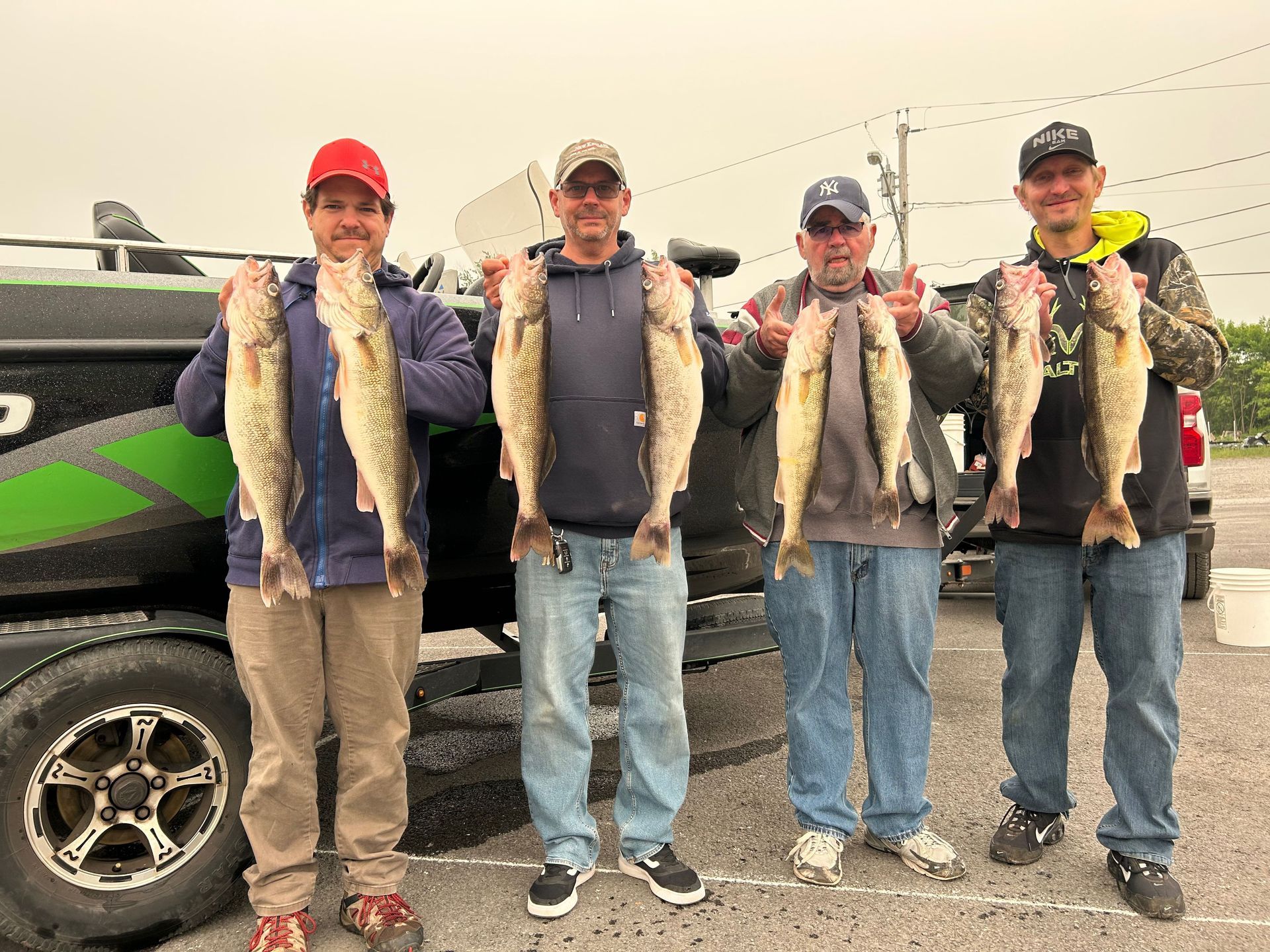 group of men standing in front of a boat holding caught Walleye fish
