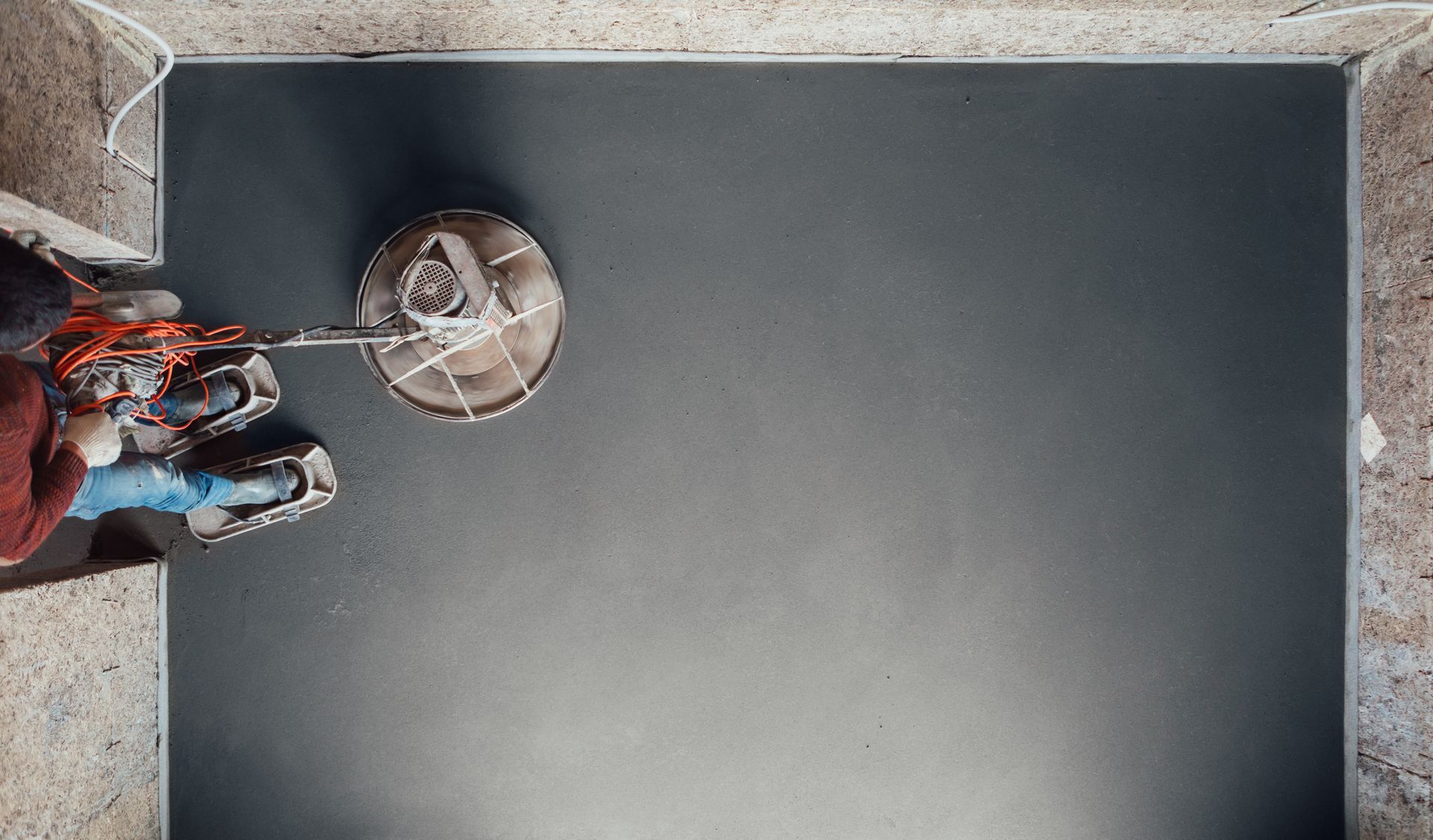A person is using a machine to polish a black floor.