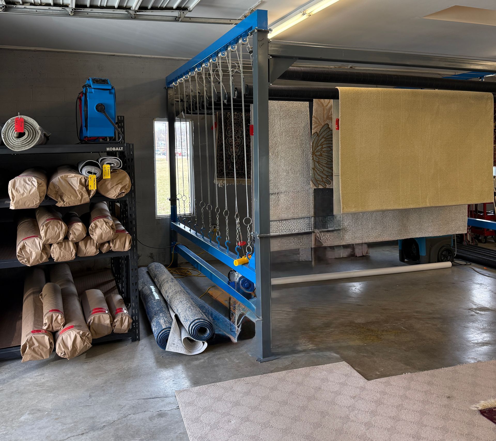 Robert's Cleaning and Restoration - A room with a lot of carpets hanging on a rack