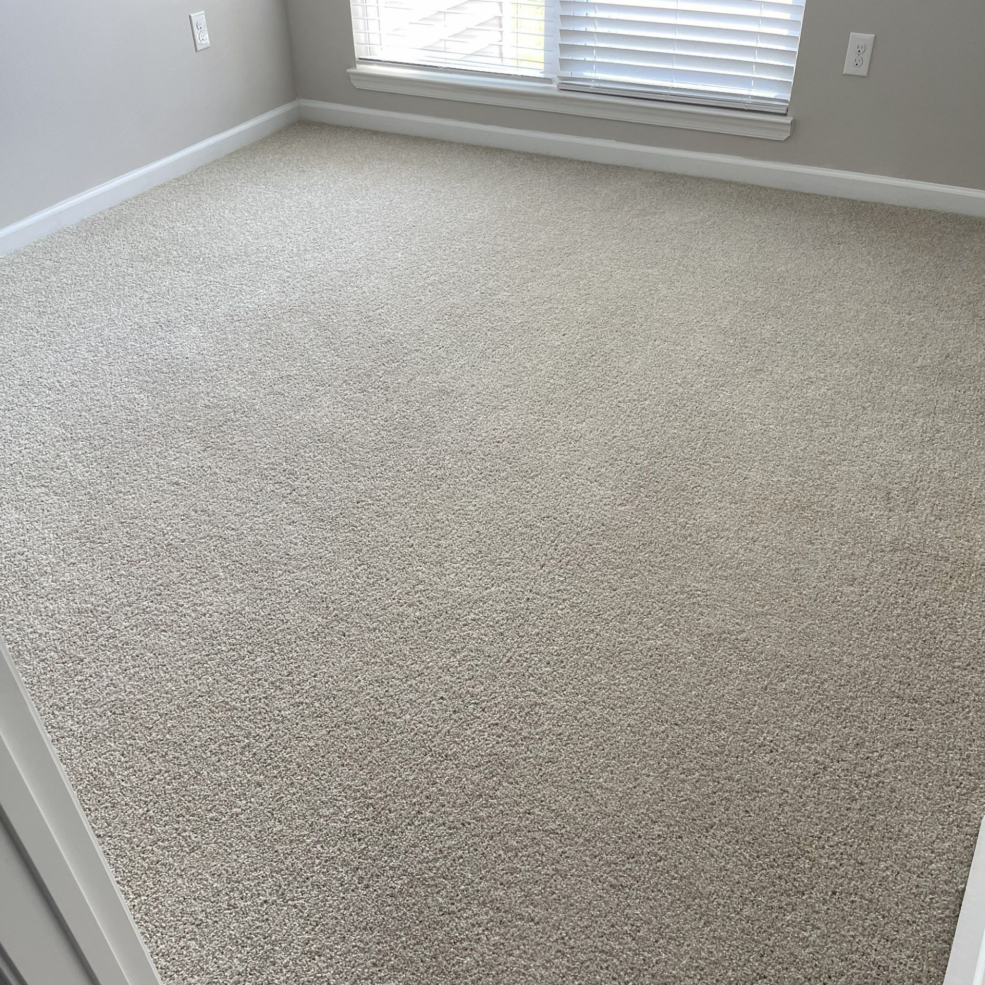 Robert's Cleaning and Restoration - A bedroom with a large carpeted floor and a window.