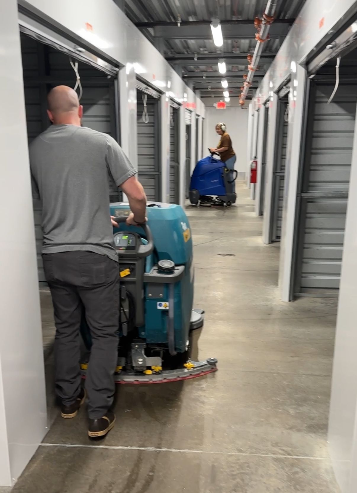 Robert's Cleaning and Restoration - A man is cleaning a hallway with a machine.