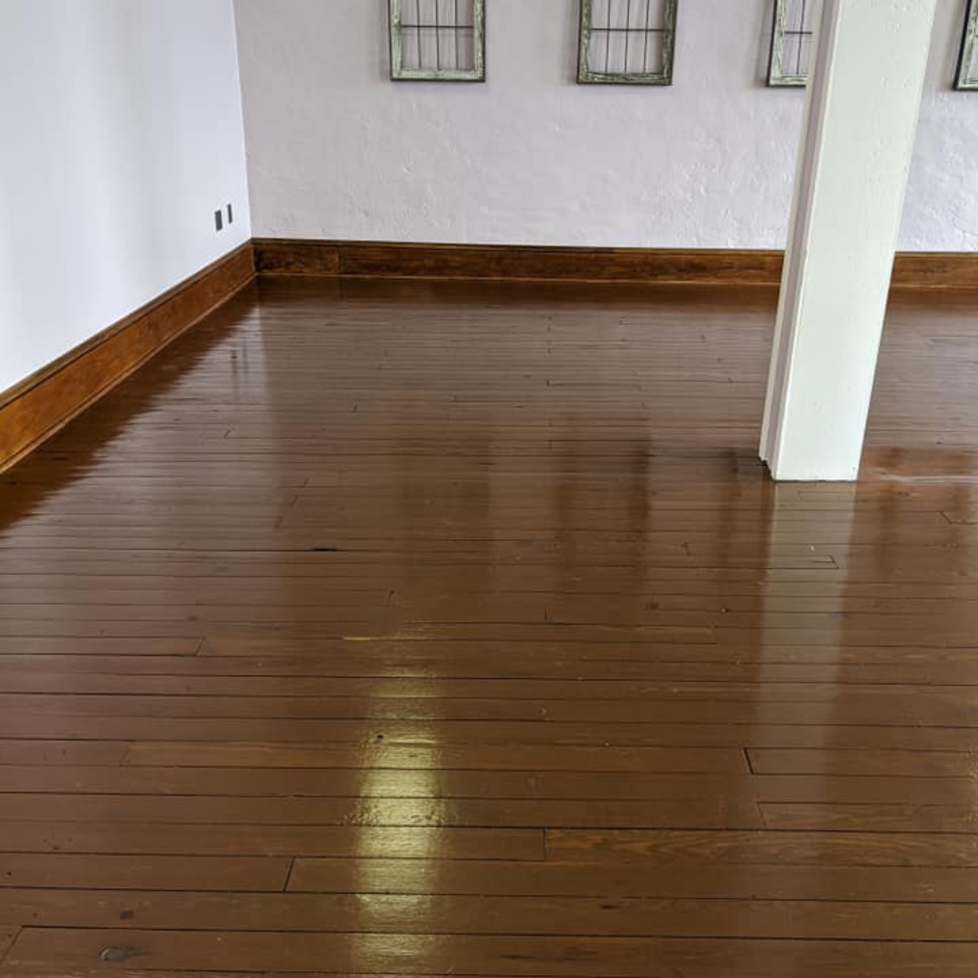Robert's Cleaning and Restoration - A room with a wooden floor and a white wall.