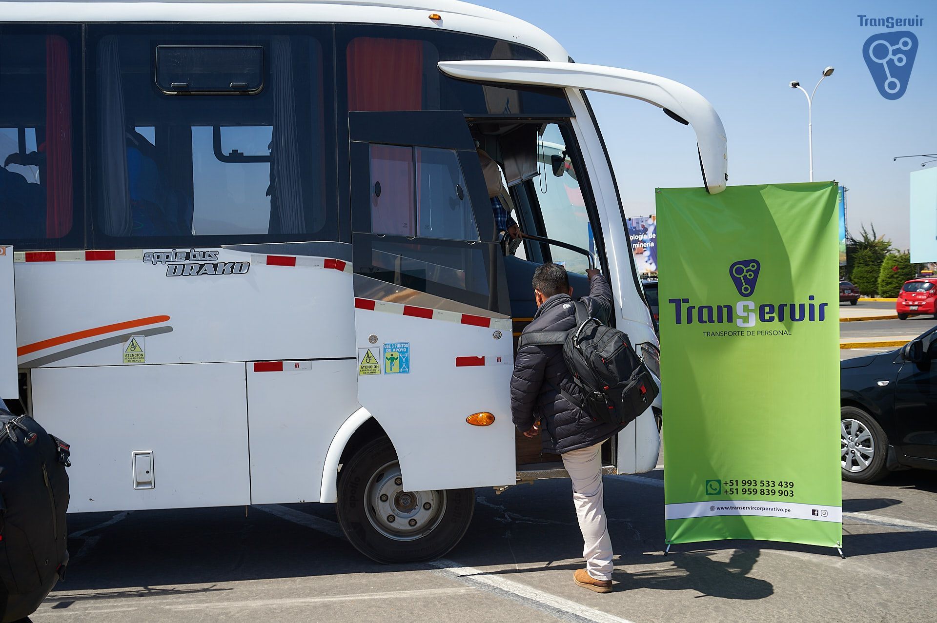 Hombre subiendo a un autobús blanco con una pancarta verde de 