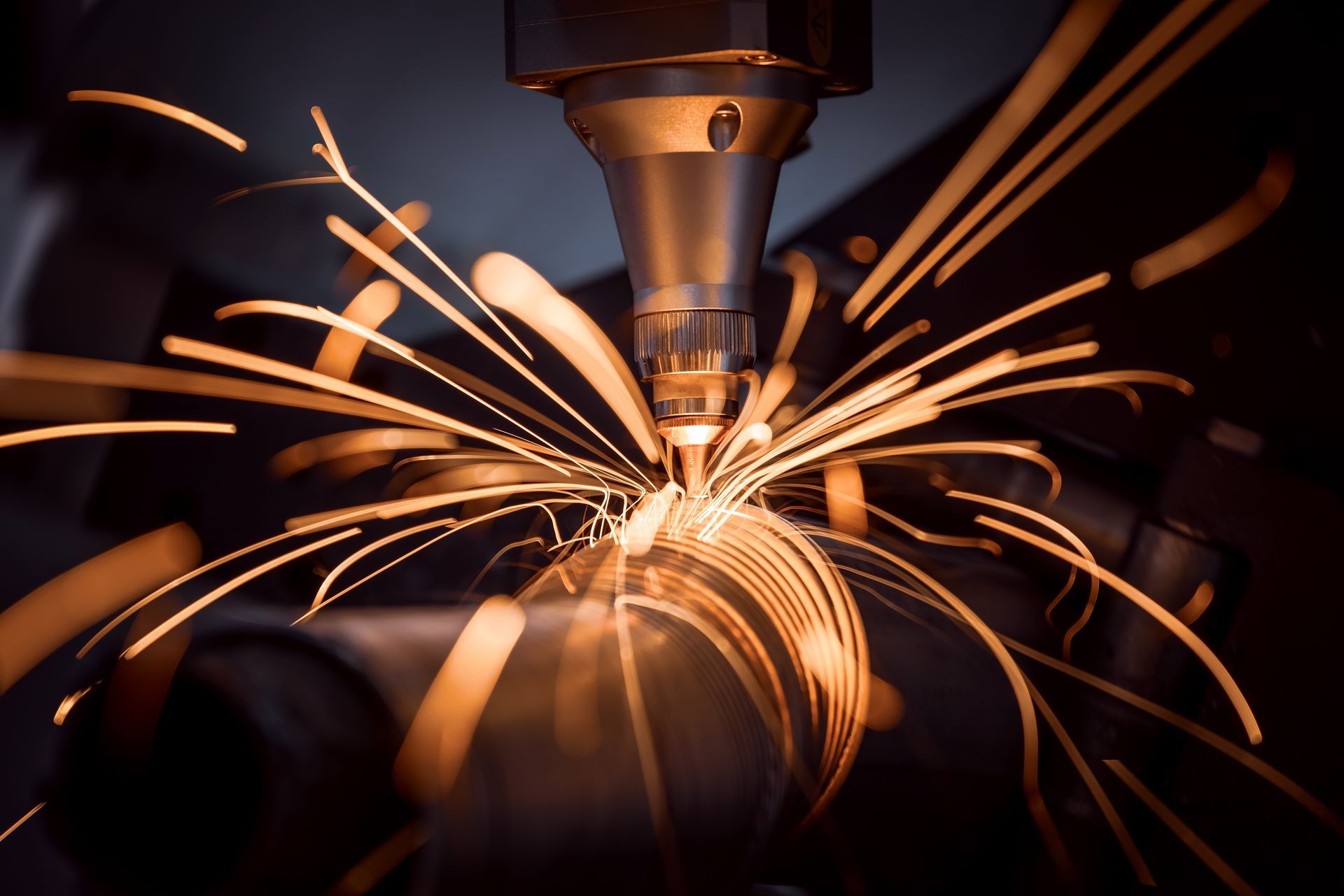 A machine is cutting a piece of metal with sparks coming out of it