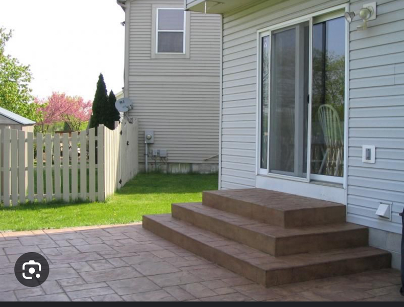 Concrete steps leading to a sliding glass door. 