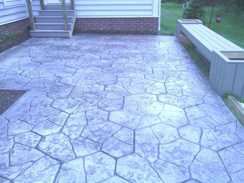 Stamped concrete patio with a hexagonal pattern and a bench.