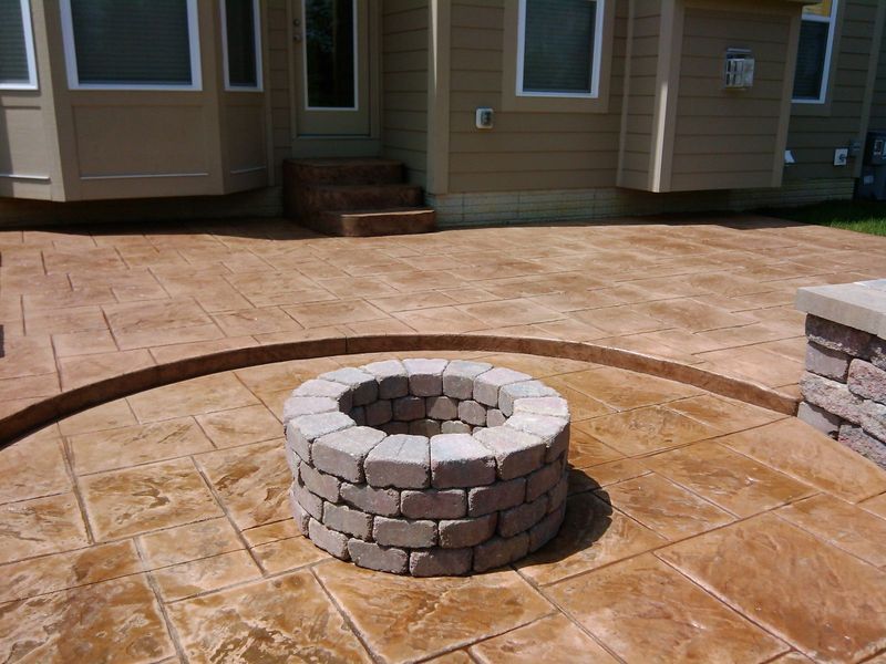 Stamped concrete patio with a brick fire pit.