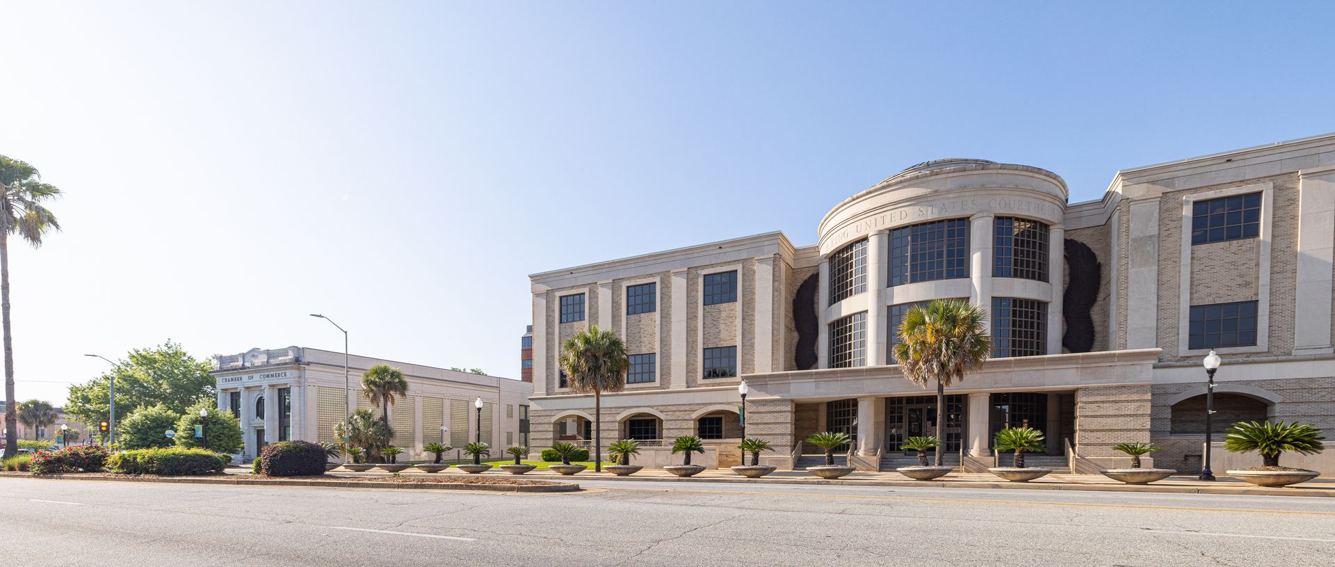 A large building with a lot of windows and palm trees in front of it