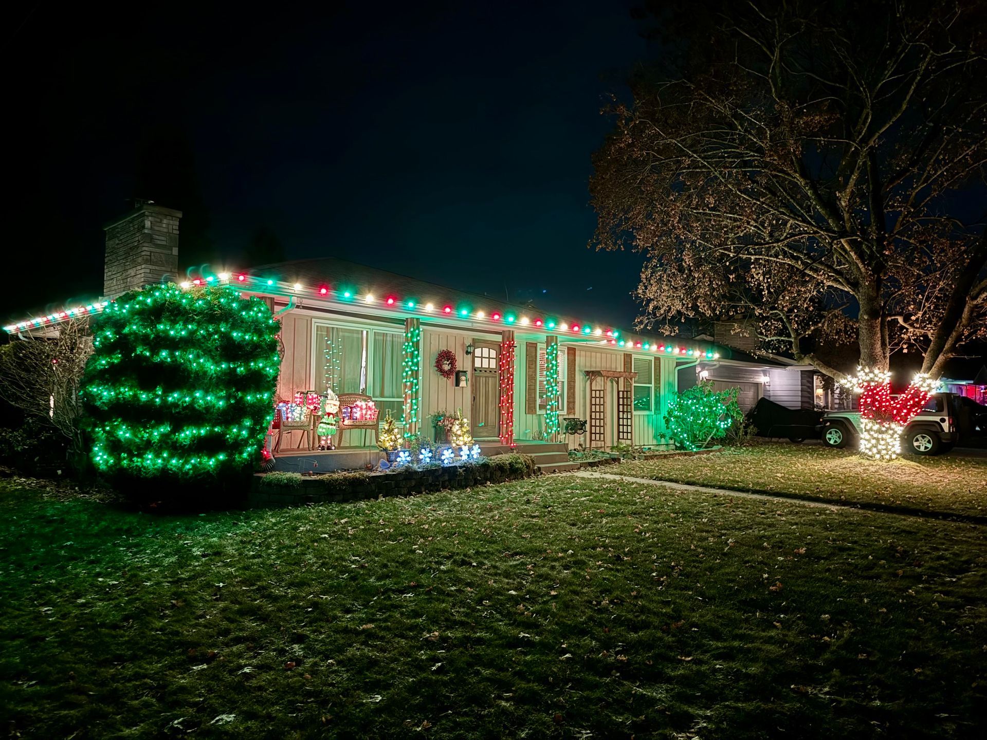 A house is decorated with christmas lights at night.