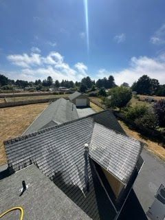 An aerial view of a house 's roof on a sunny day.