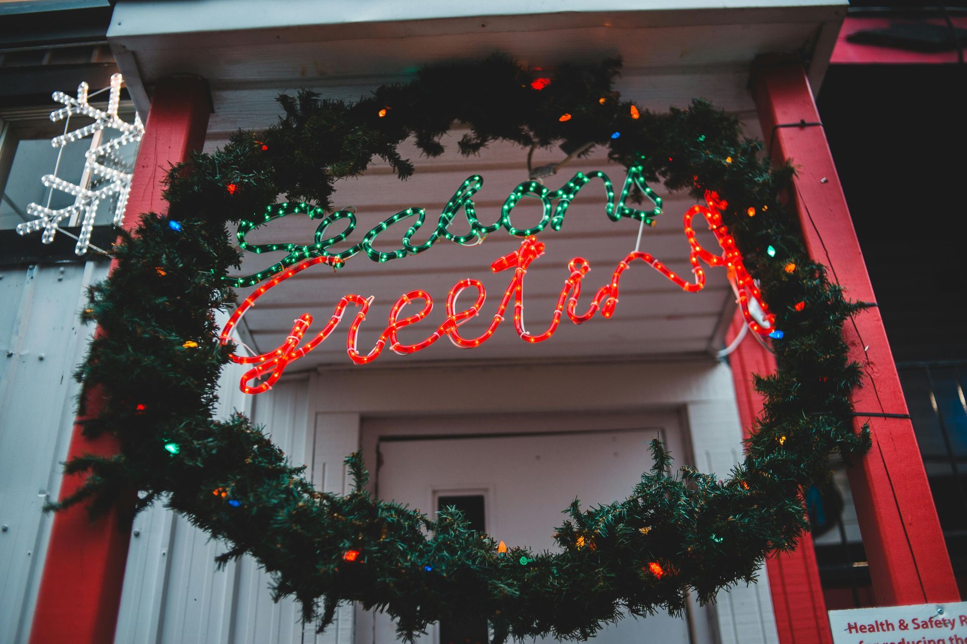 A christmas wreath with the word greetings on it