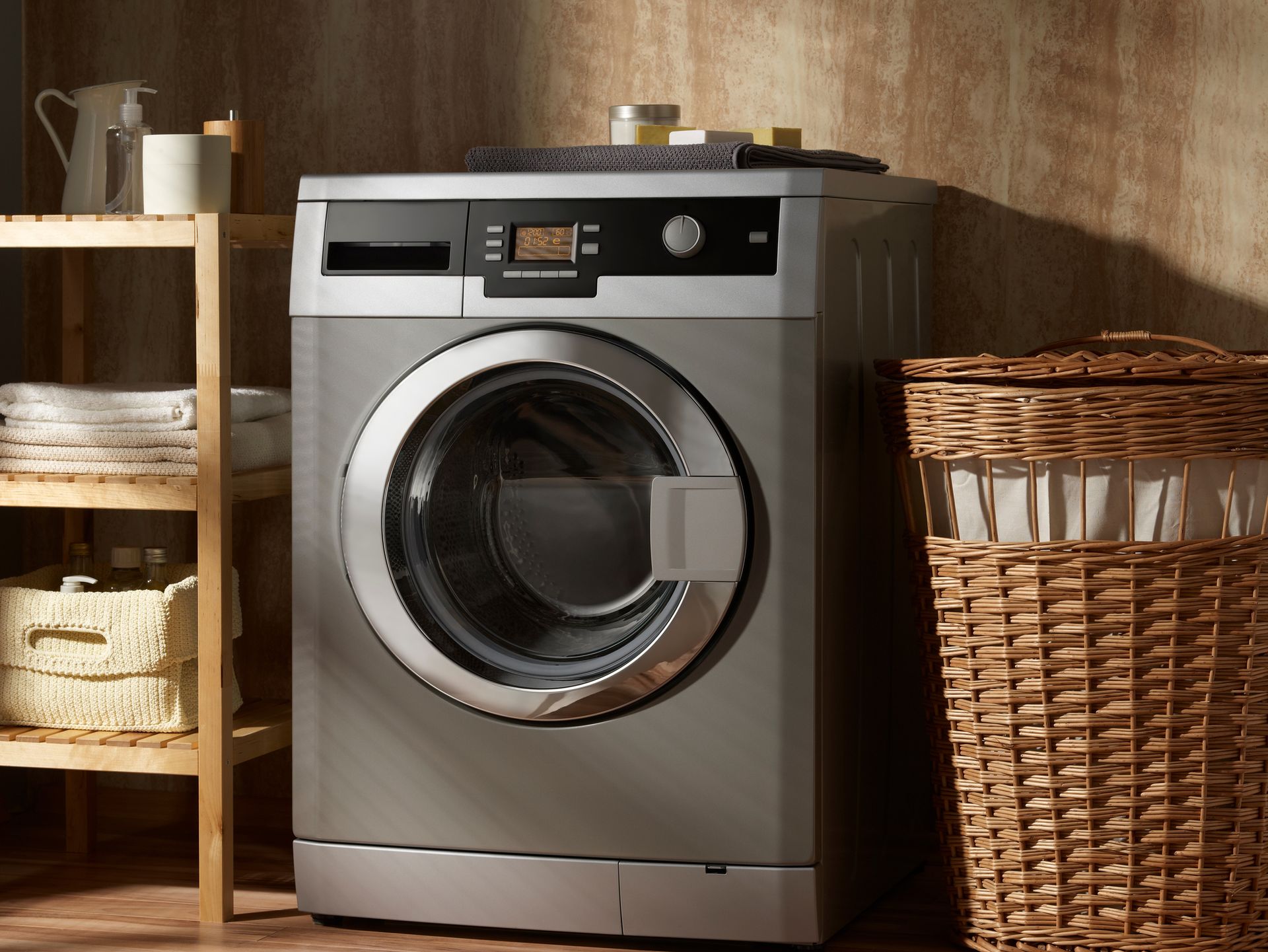 Washing machine in a laundry room with a wooden shelf, basket, and wicker hamper.