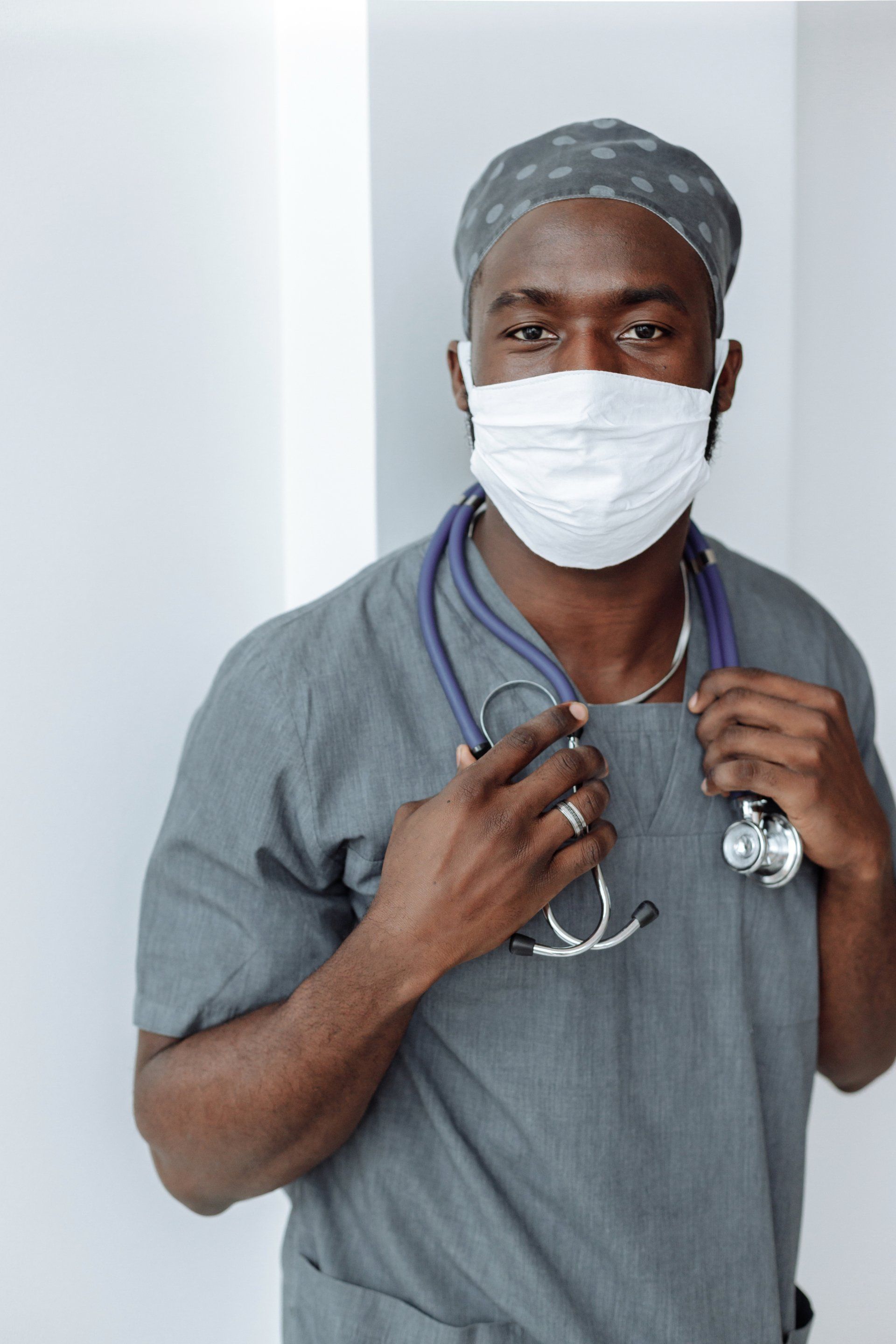 A doctor wearing a mask and a stethoscope around his neck.