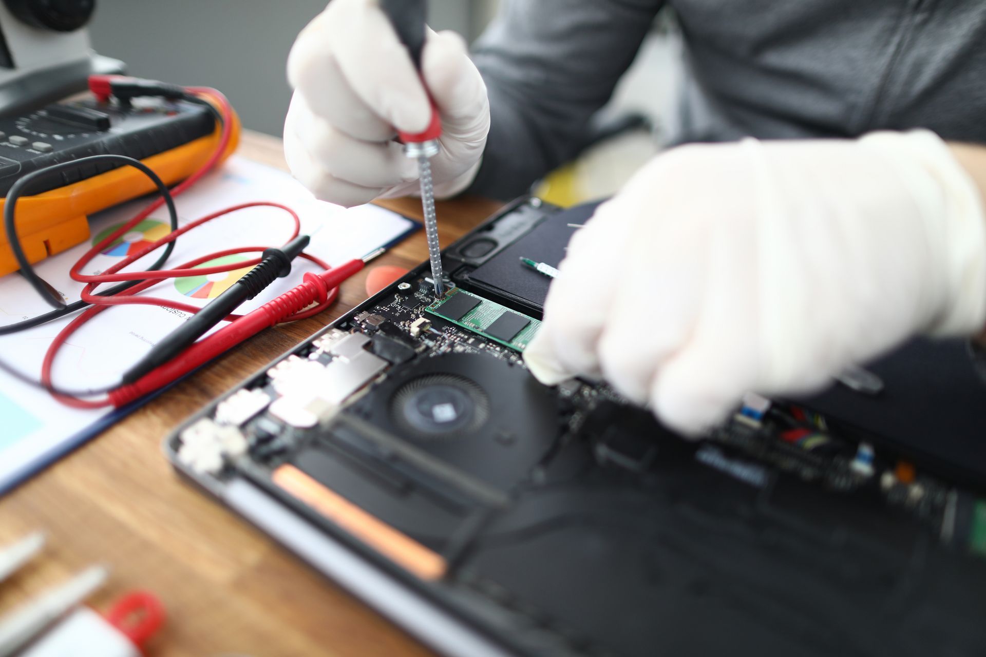A person performing a laptop repair