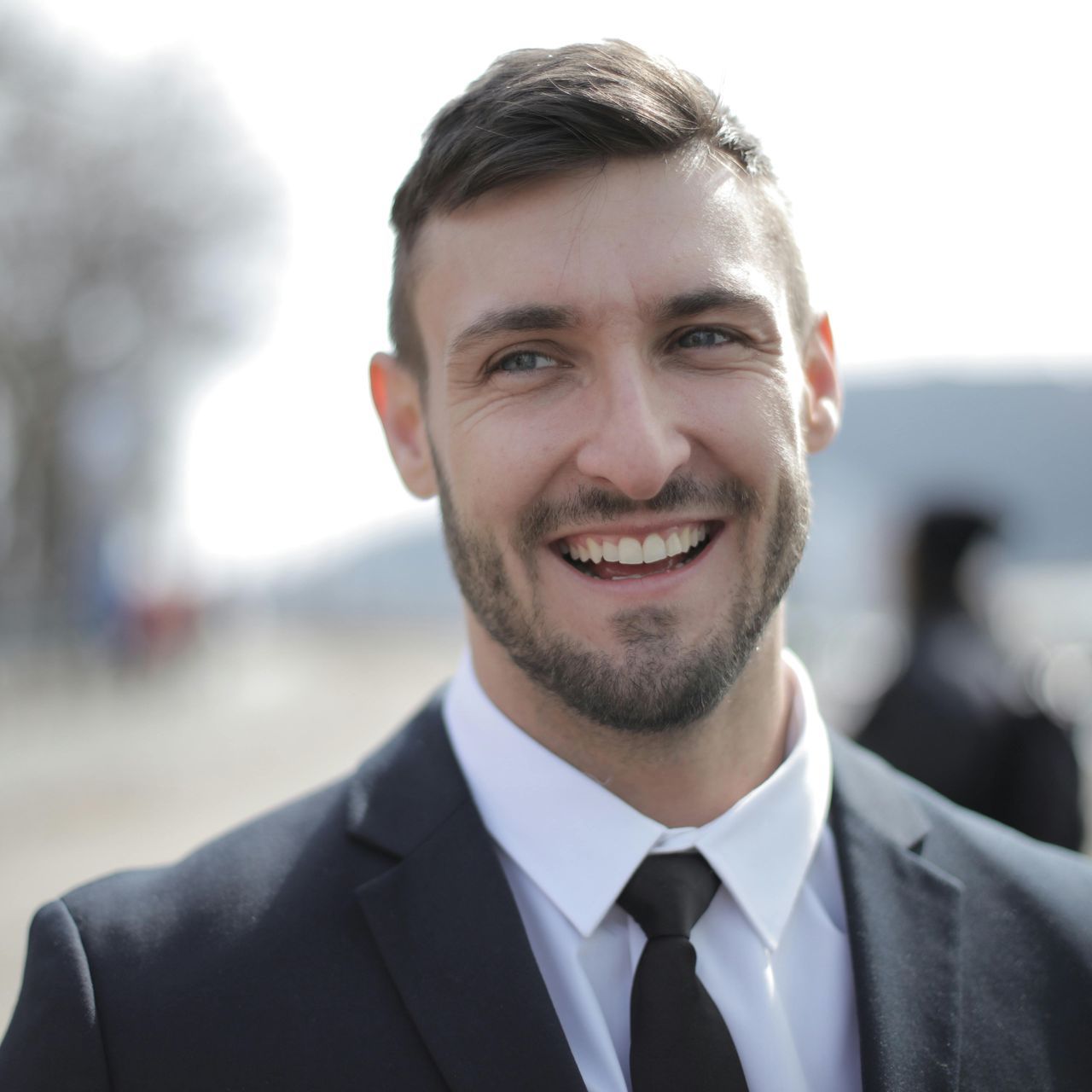 A man in a suit and tie is smiling for the camera.