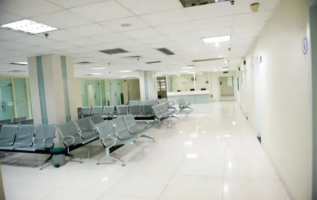 A hospital waiting room with a lot of chairs and a counter.