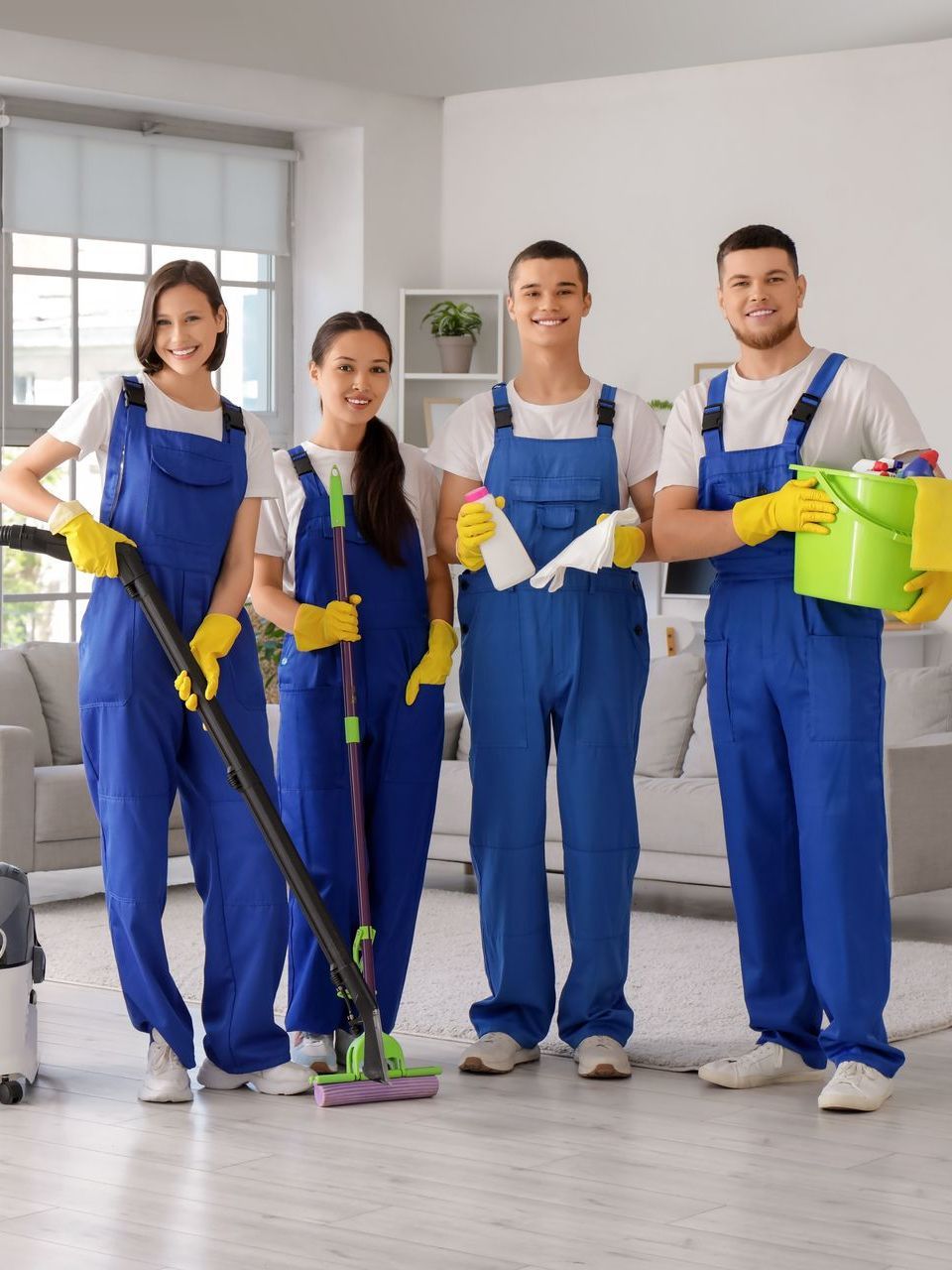 A group of cleaners are posing for a picture in a living room.
