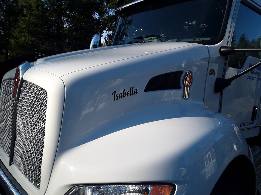 A white truck with the name isabella on the hood