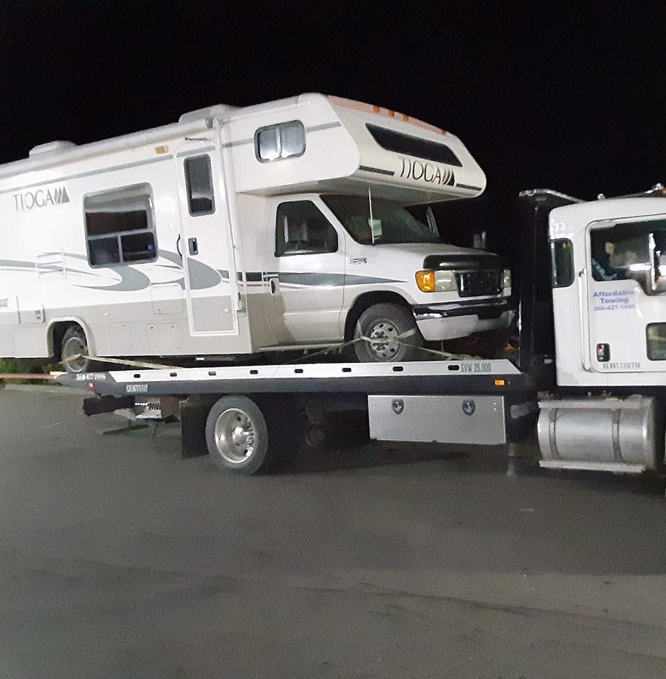 A rv is being towed by a tow truck