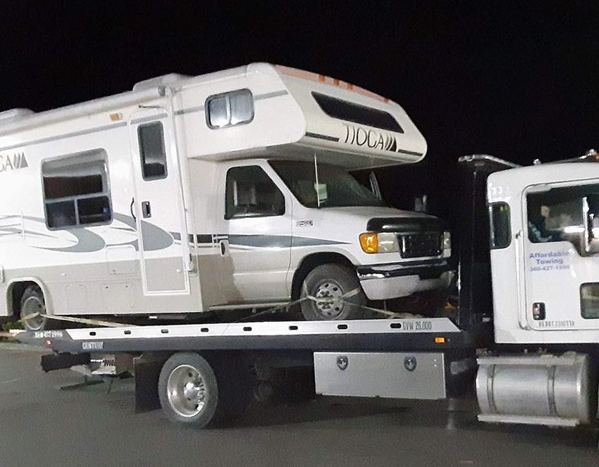 A rv is being towed by a tow truck