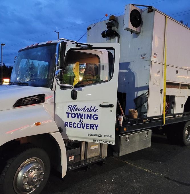 An affordable towing recovery truck is parked in a parking lot