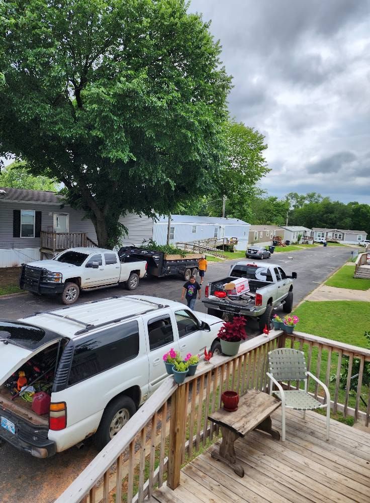 Mobile home park with trucks and people, cloudy day.