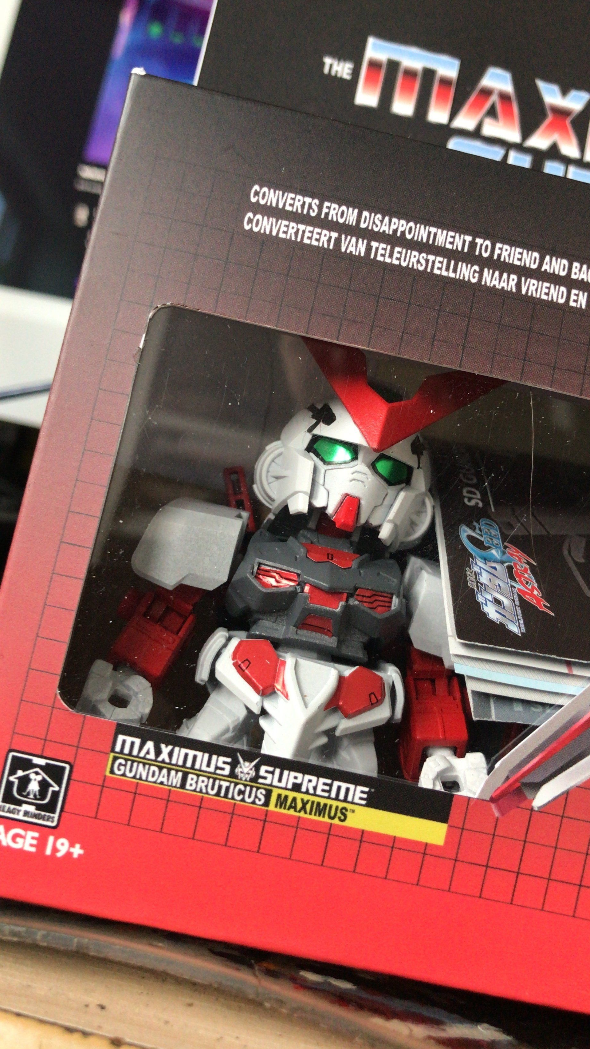 A toy robot is sitting on top of a box on a table.