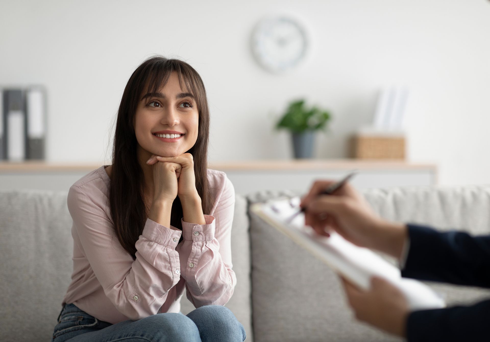 A woman is sitting on a couch talking to a psychologist