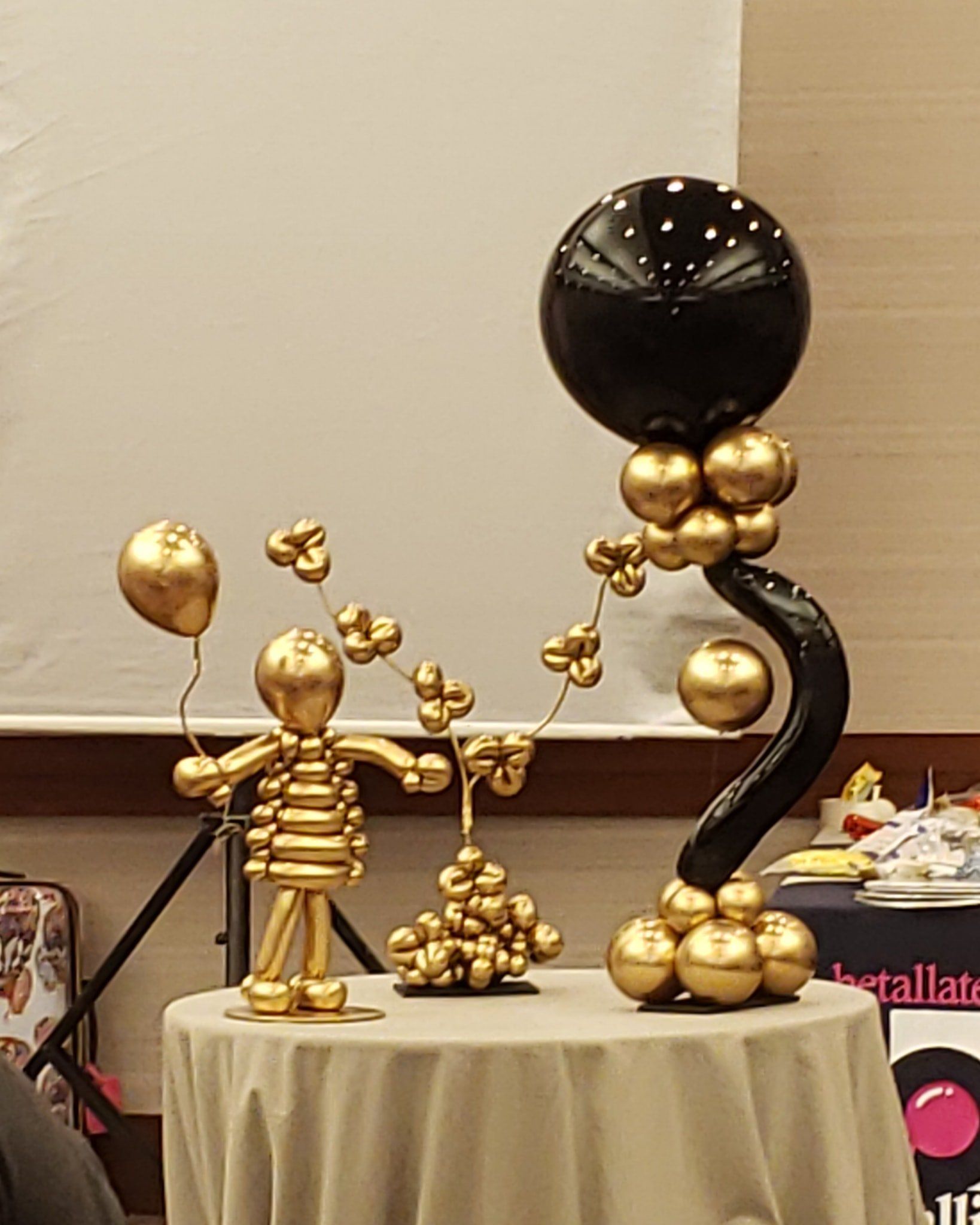 Custom asymmetrical black and gold centerpiece for corporate event.