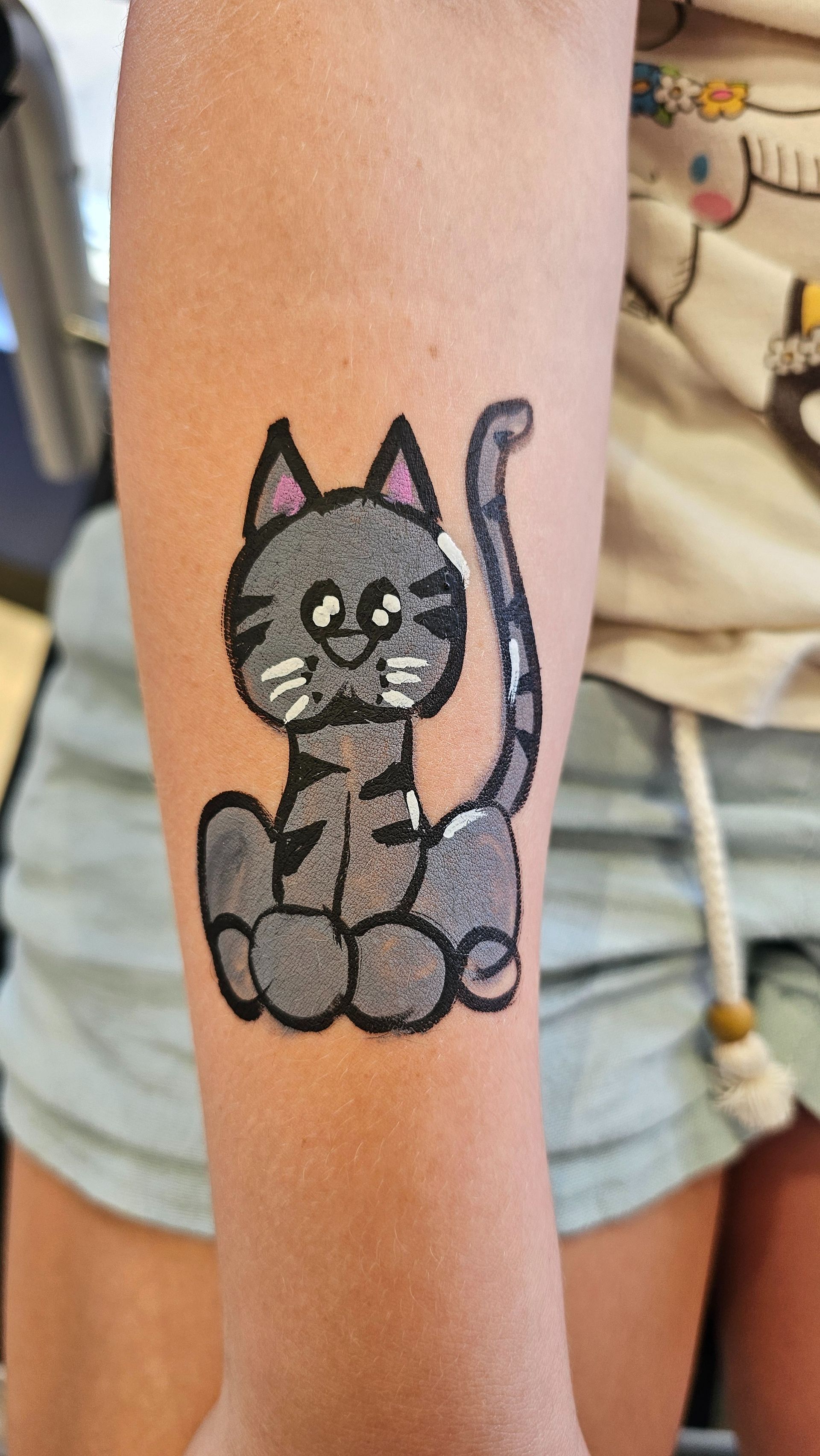 Grey kitty painted on forearm.