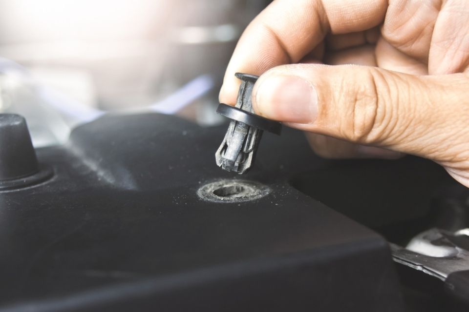 A close up of a person holding a plastic clip in their hand.