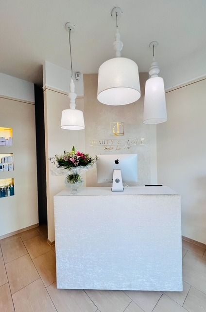 Ein weißer Schreibtisch mit einem Apple-Computer darauf