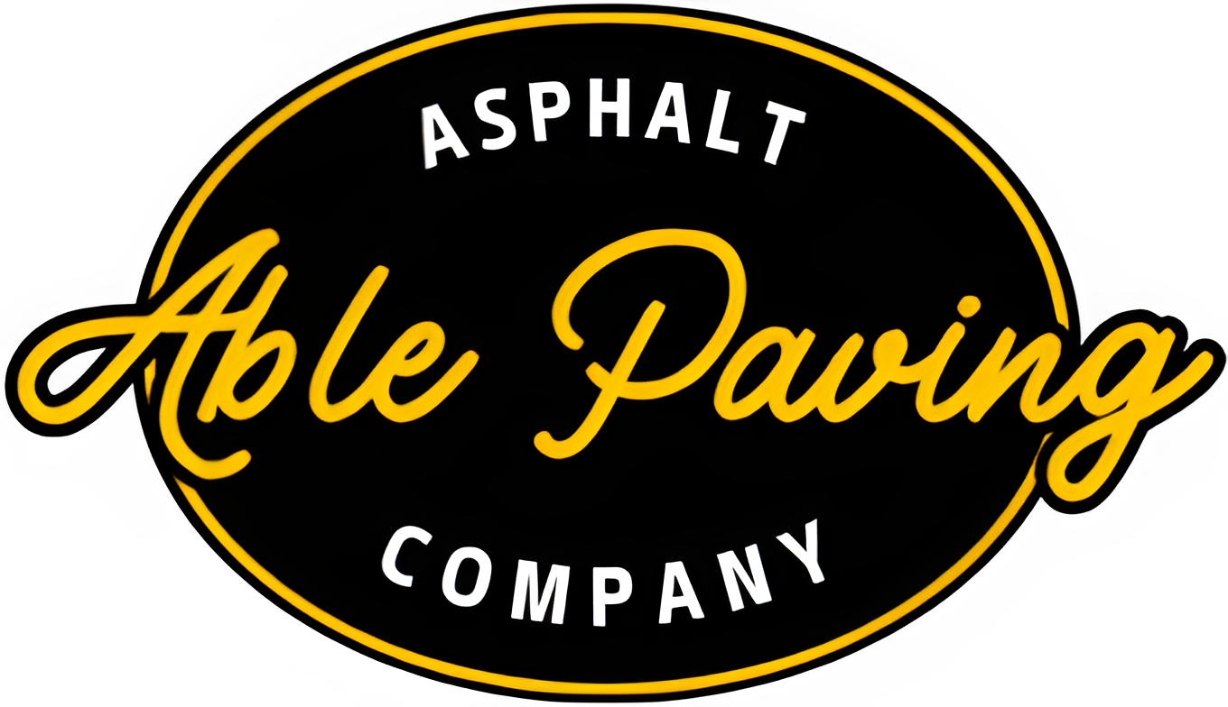 Oval logo for Able Paving Company with yellow text on a black background.