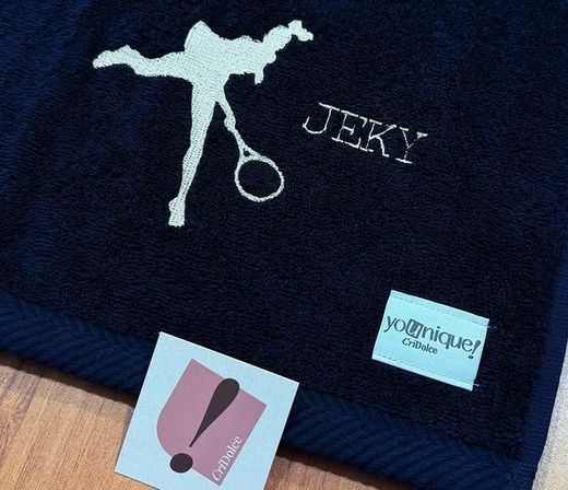 Asciugamano blu scuro ricamato con la silhouette di un tennista bianco e il nome 