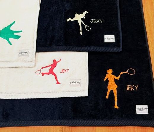 Asciugamani da golf piegati, nei colori nero, bianco e rosso, con sagome di golfisti colorati e logo JEKY.